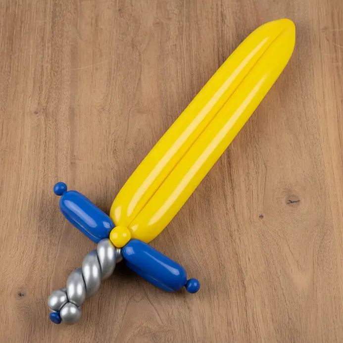 A dual-colored balloon twisted into a sword shape with a hilt and blade.